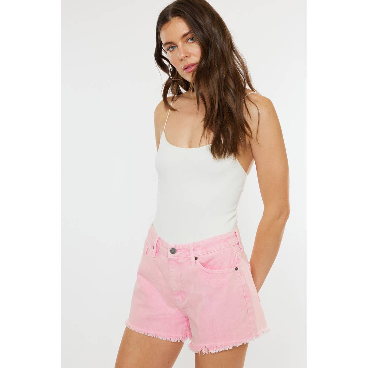 slight side view of Kan Can USA pink high rise denim shorts with frayed hem