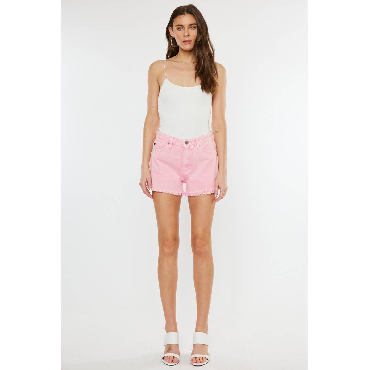 zoomed out styled view of Kan Can USA pink high rise denim shorts with frayed hem