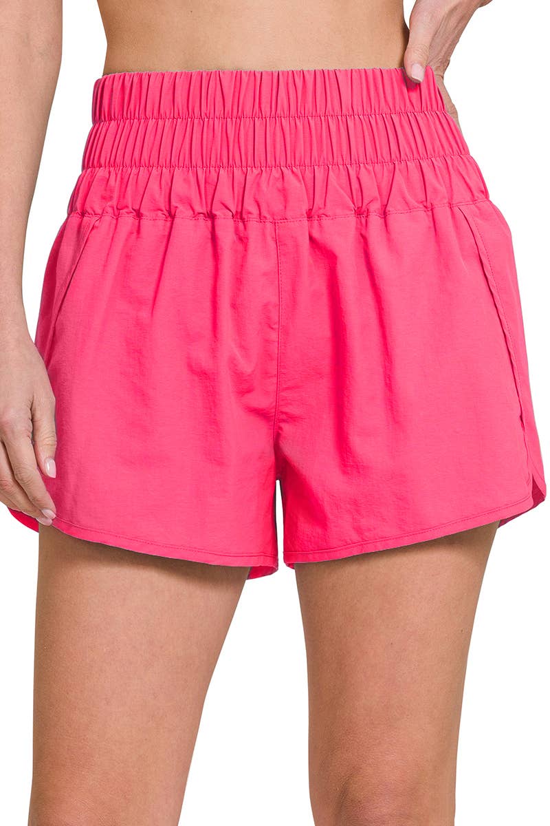 front view of Fuchsia Smocked Waistband Running Shorts with mesh waist pocket, split hem, and built-in inner brief. Made from 100% nylon shell and 96% polyester, 4% spandex lining, with a total waist of 27" and inseam of 2 3/8".