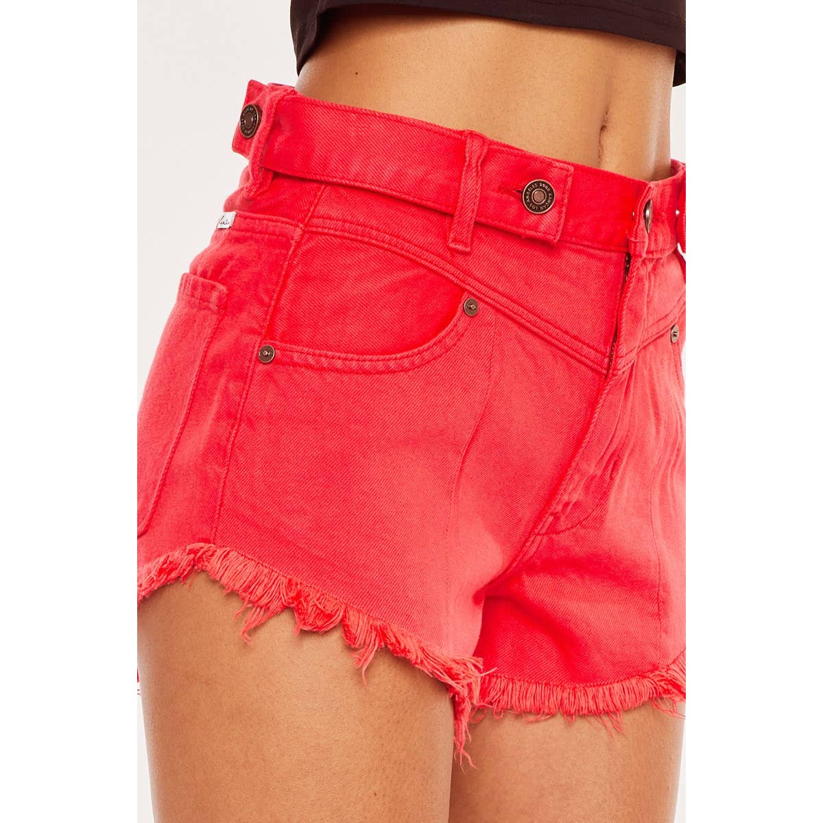 pocket view detail of Kan Can USA high rise coral red shorts with frayed hem and button accent