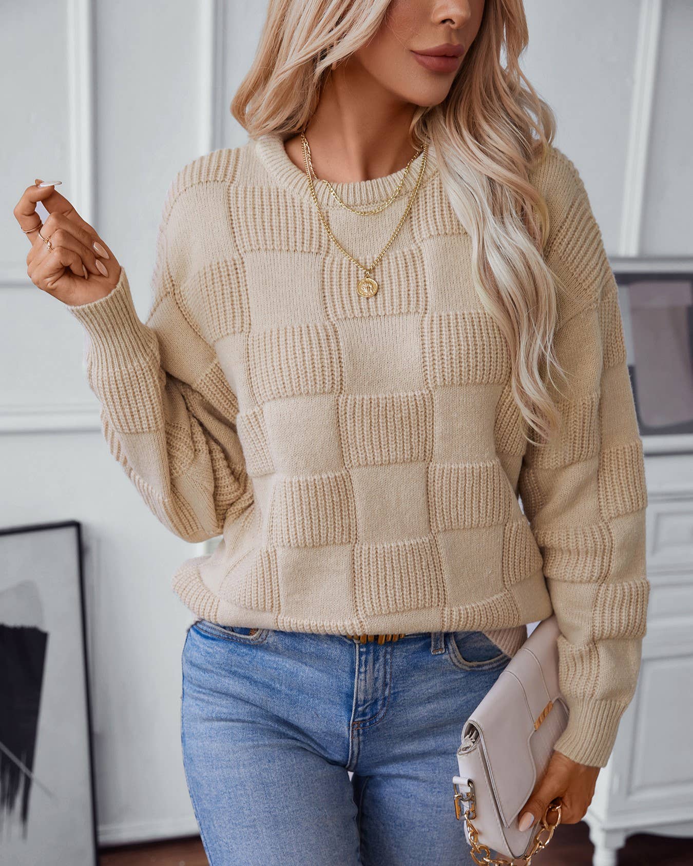 one arm up styled view of Apricot minimalist checked crewneck sweater featuring a subtle checked pattern and a comfortable, stylish fit.