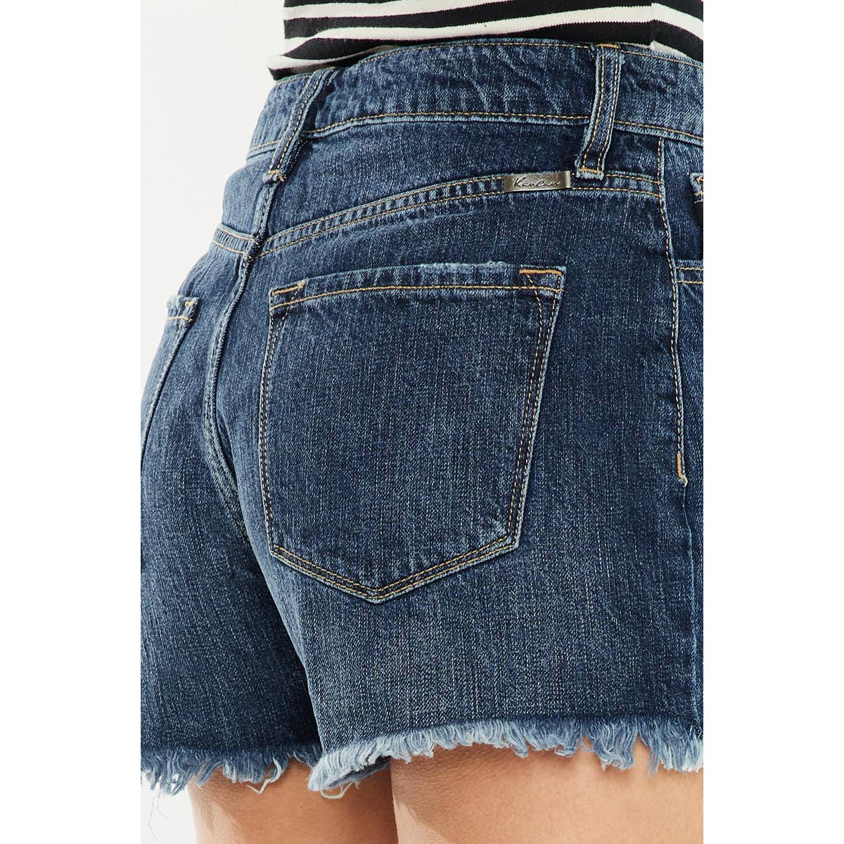 pocket detail view of Kan Can USA high rise mom shorts with dark stone wash and raw frayed hem