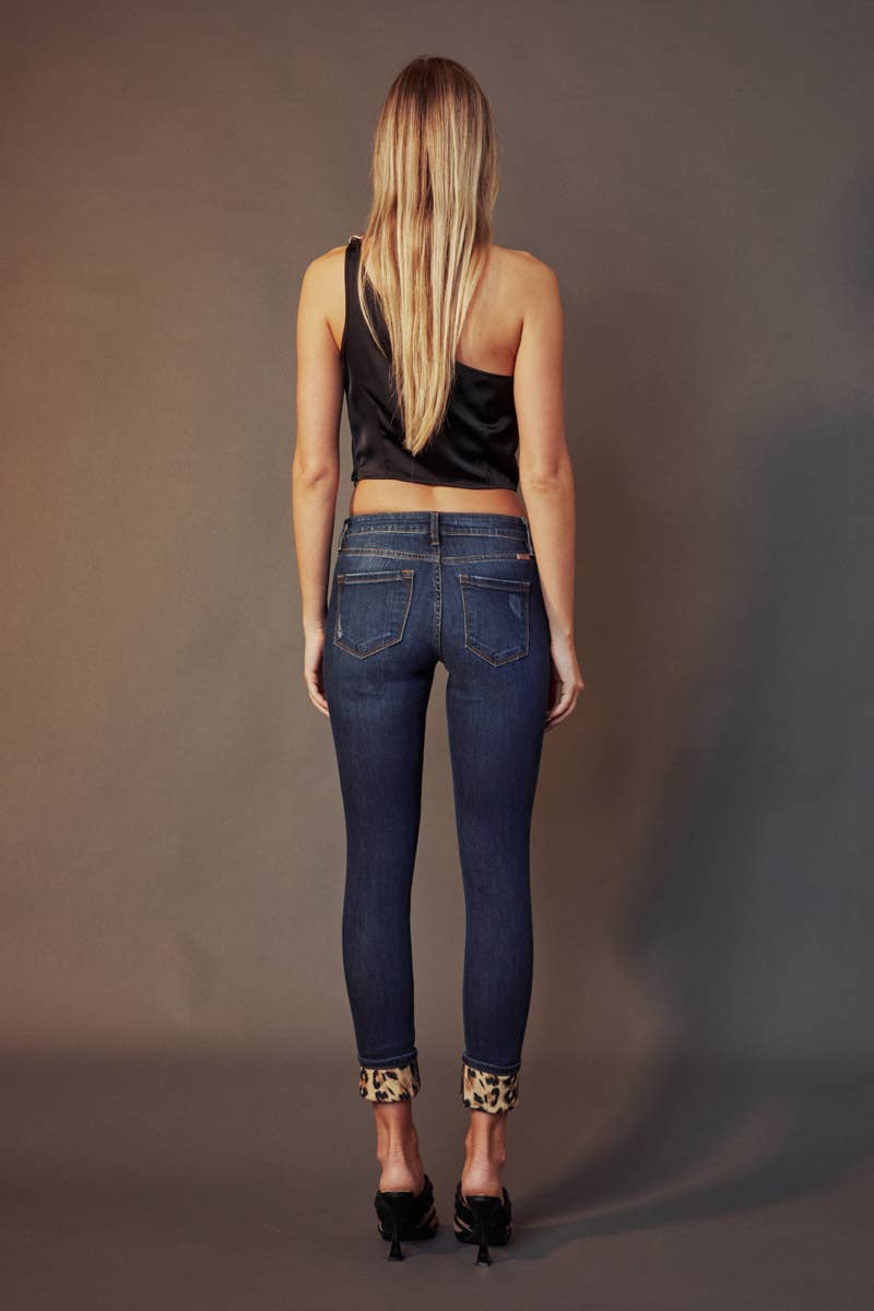 back view of Kan Can Mid Rise Leopard Patch Super Skinny Jeans in Dark Wash with leopard patch details, 5-pocket design, and a zip fly. Features an 8.5" rise and 29.5" inseam (before folding), made from a blend of cotton, polyester, rayon, and Lycra.