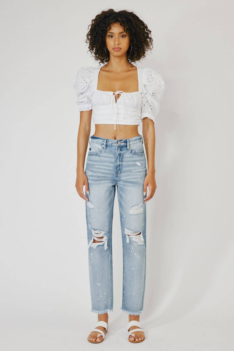 zoomed out view of High Rise Slim Straight Jeans in Medium Stone Wash, featuring a 12" rise, 28" inseam, rigid 100% cotton fabric, frayed hem, paint splatter accents, and distressed details with a zip fly.