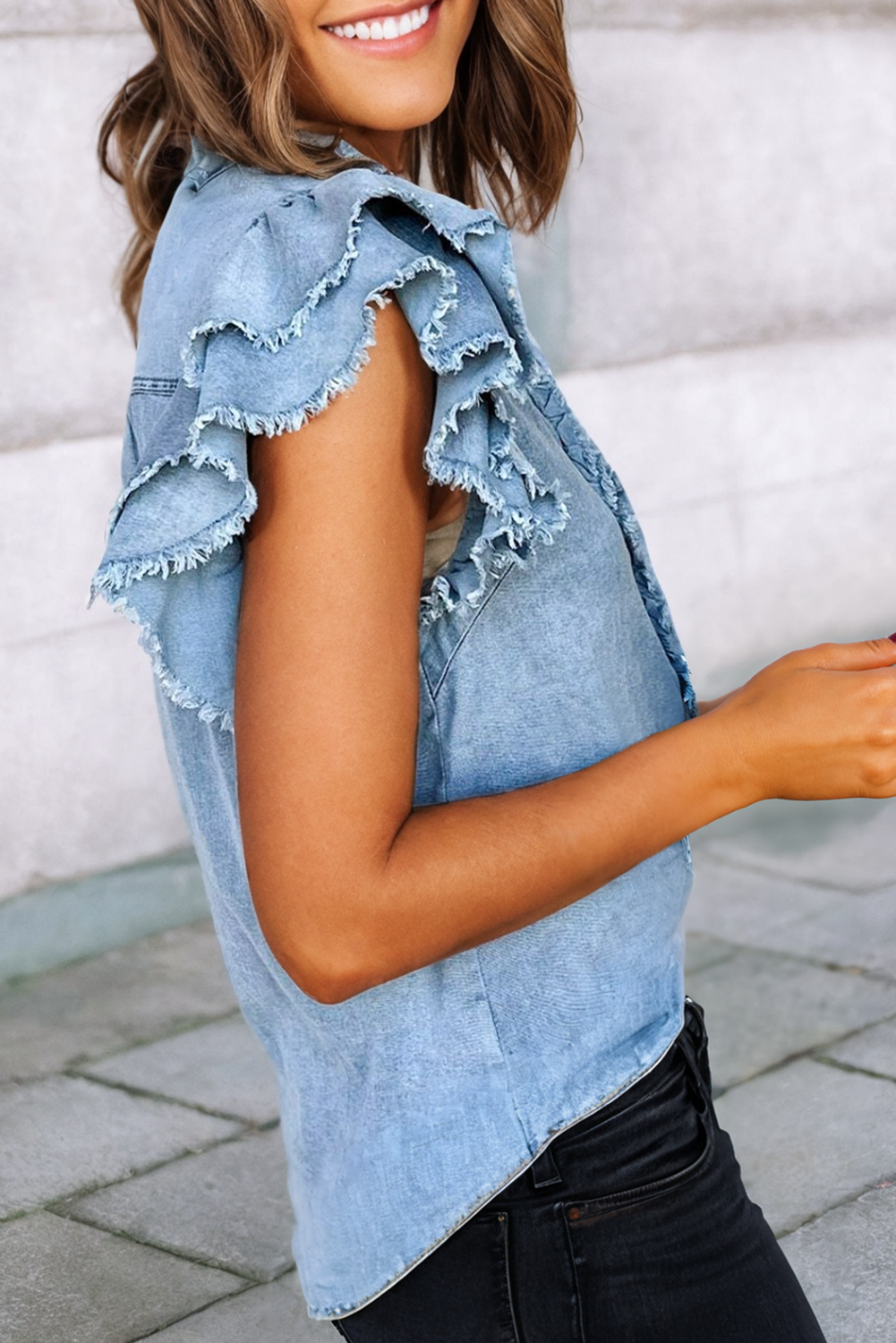 sleeve detail of Button front denim blouse with ruffle and flutter sleeves, featuring a frayed hem for a casual and chic look.