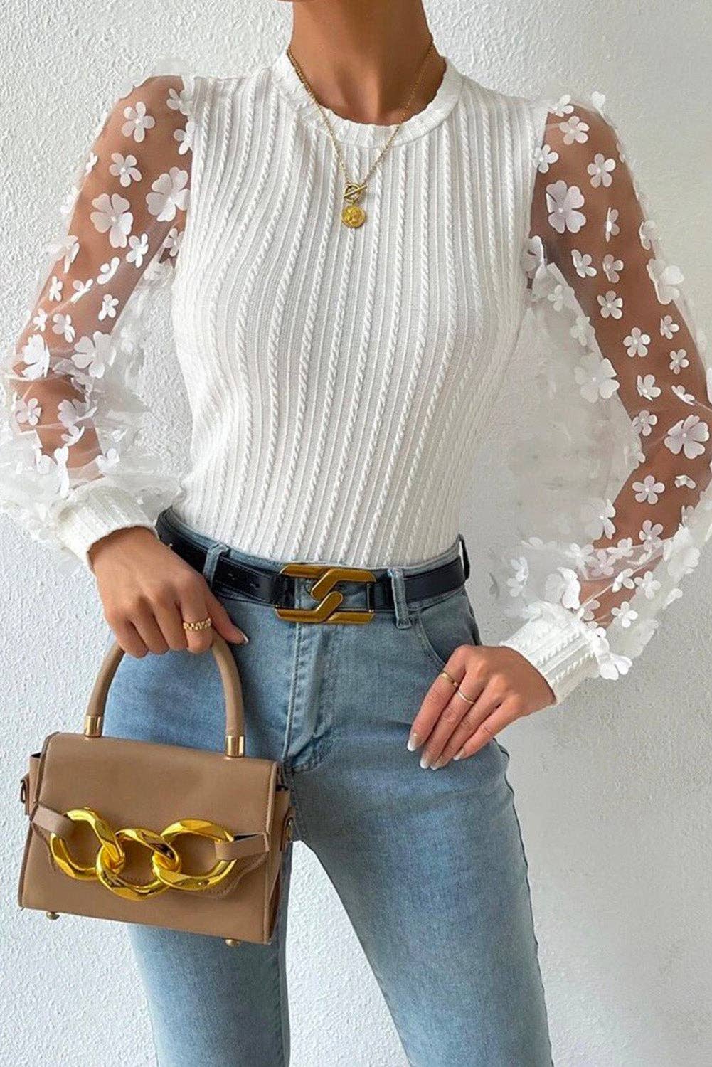 styled view of white Textured knit blouse with floral applique mesh sleeves, crew neck, and elegant detailing for a chic and sophisticated look.