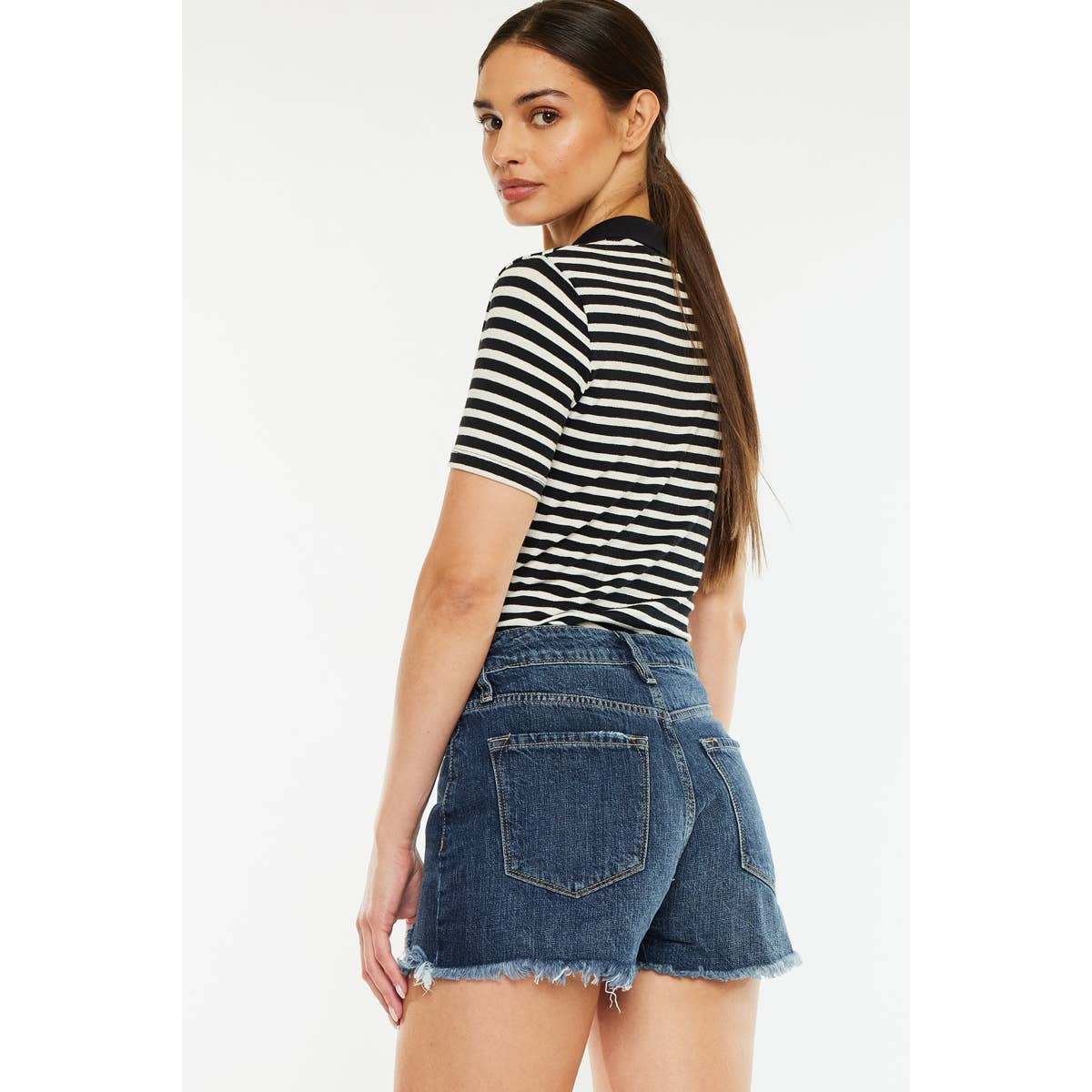 slight back view of Kan Can USA high rise mom shorts with dark stone wash and raw frayed hem