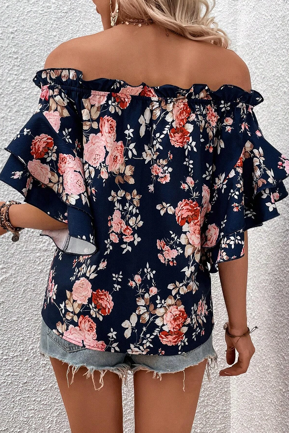 back view of Feminine ruffle off-shoulder blouse with flounce sleeves and floral print, offering a trendy and romantic look with playful ruffle detailing.