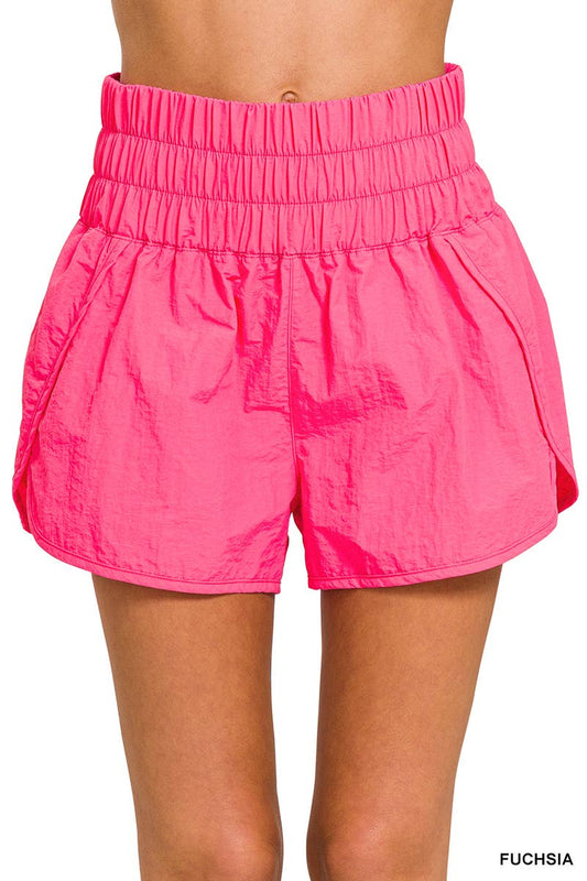 Fuchsia Smocked Waistband Running Shorts with mesh waist pocket, split hem, and built-in inner brief. Made from 100% nylon shell and 96% polyester, 4% spandex lining, with a total waist of 27" and inseam of 2 3/8".